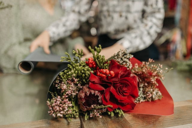 Red rose bouquet on a wooden table.